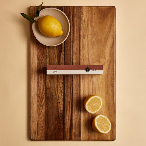 Whetstone showing 1000 and 3000 grit sides on a cutting board with lemons