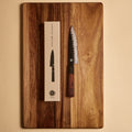 Petty knife next to its gift box packaging on a cutting board