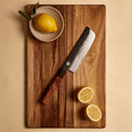 Nakiri knife from the three knife set on a cutting board with lemons