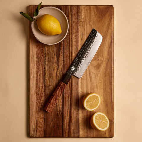 Nakiri knife from the three knife set on a cutting board with lemons